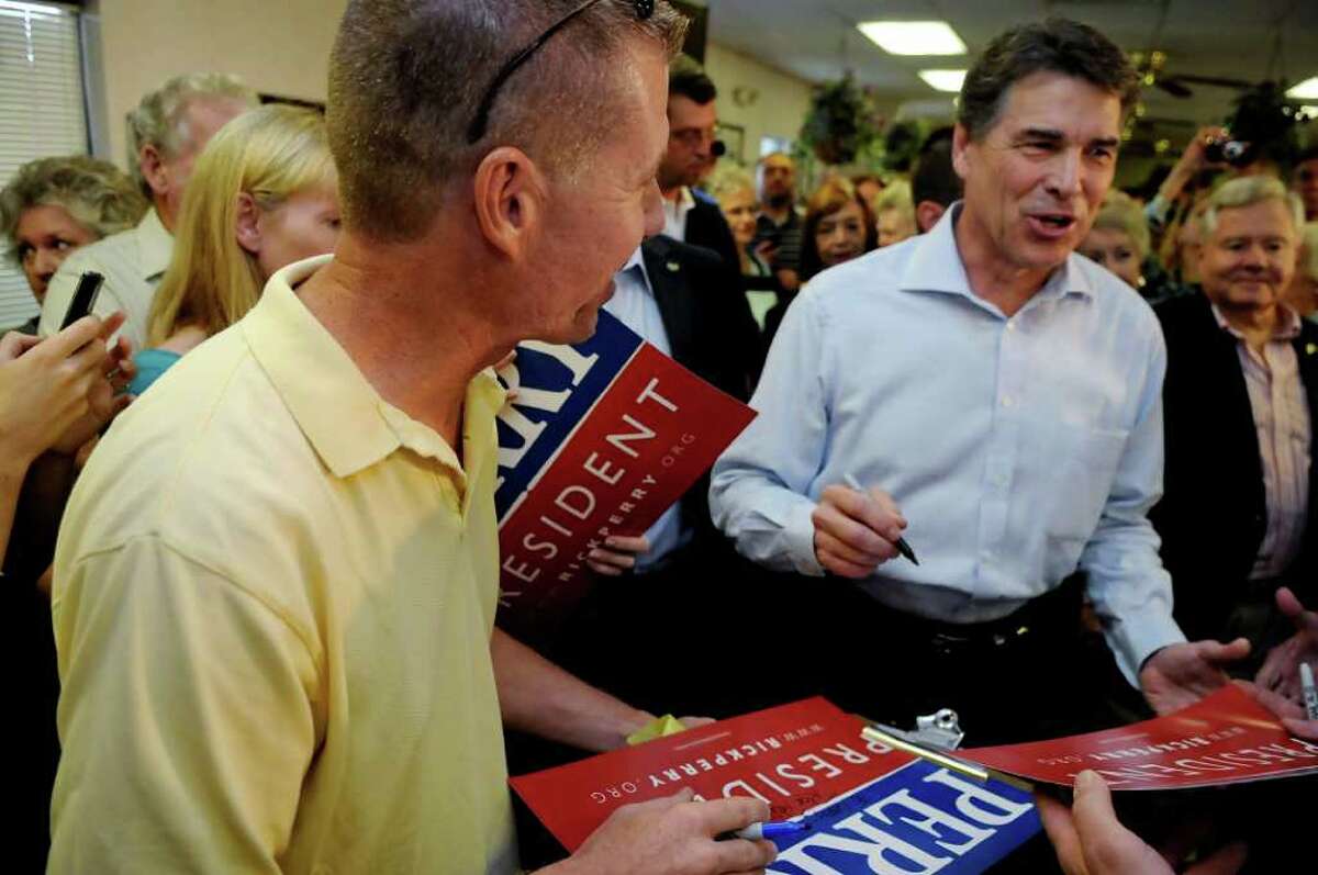 Republican presidential candidate, Texas Gov. Rick Perry, signs autographs for supporters at Tommy's Ham House Saturday, August 20, 2011, in Greenville, S.C. (AP Photo/ Richard Shiro)
