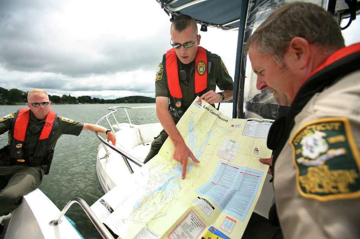 From left; State Environmental Conservation Police officers Keith Williams, Sean Buckley, and Tige Wade, look over a map during a patrol of Candlewood Lake in Brookfield on Tuesday, August 16, 2011.