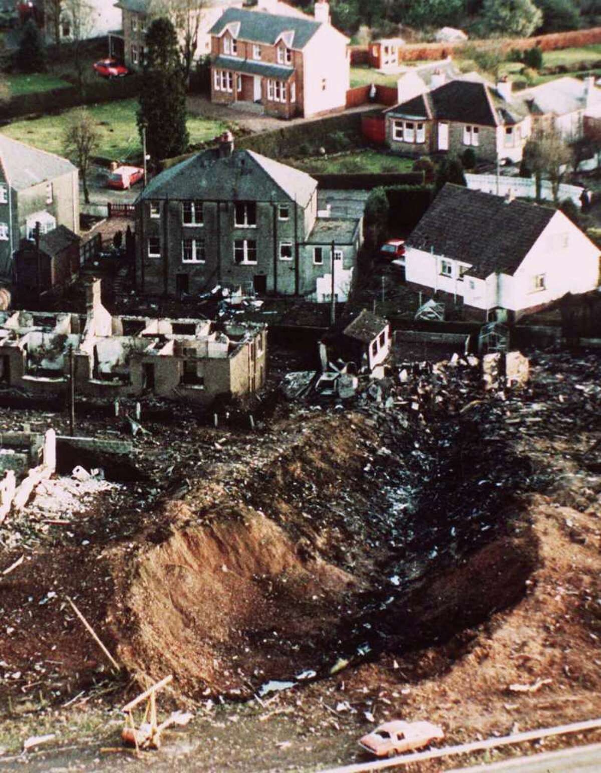A deep gash is seen in the ground next to destroyed houses after the crash of Pan Am Flight 103 in the village of Lockerbie, Scotland, is in this Dec. 21, 1988 file photo. Pan Am Flight 103, felled by a bomb hidden in a suitcase, crashed, killing 270 people in the plane and on the ground.