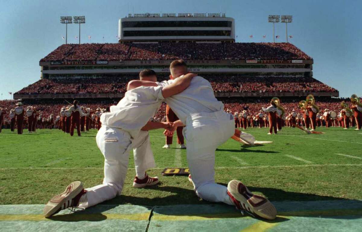 Texas A& M yell leaders Bubba Moser Jr., left, and Ricky Wood Jr., watchs as the Longhorn band performs 'Amazing Grace' during half time of the Aggies win over the Longhorns 20-16 Friday, Nov. 26, 1999 in College Station, Texas. (Smiley N. Pool/Chronicle) HOUCHRON CAPTION (11/28/1999): Texas A&M yell leaders Bubba Moser Jr., left, and Ricky Wood Jr., watch from the sideline as the University of Texas Longhorn band performs 'Amazing Grace' during half time in honor of the 12 Aggies who died last week in the Bonfire collapse.