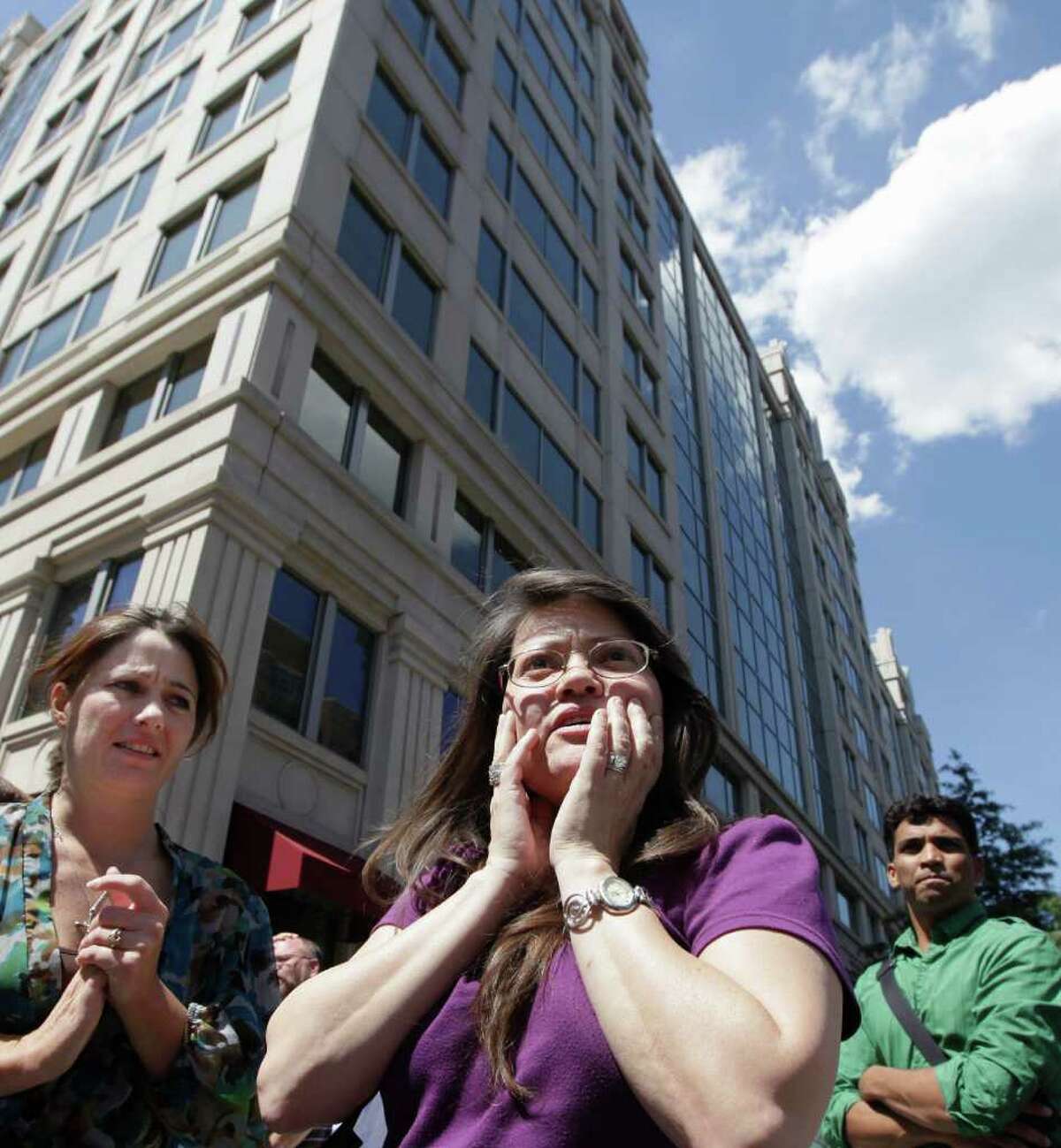 Susy Ward, center, and other office workers gather on the sidewalk in downtown Washington moments after an earthquake shook the nation's capitol, Tuesday, Aug. 23, 2011. The 5.9 magnitude earthquake centered northwest of Richmond, Va., shook much of Washington, D.C., and was felt as far north as Rhode Island and New York City. (AP Photo/J. Scott Applewhite)