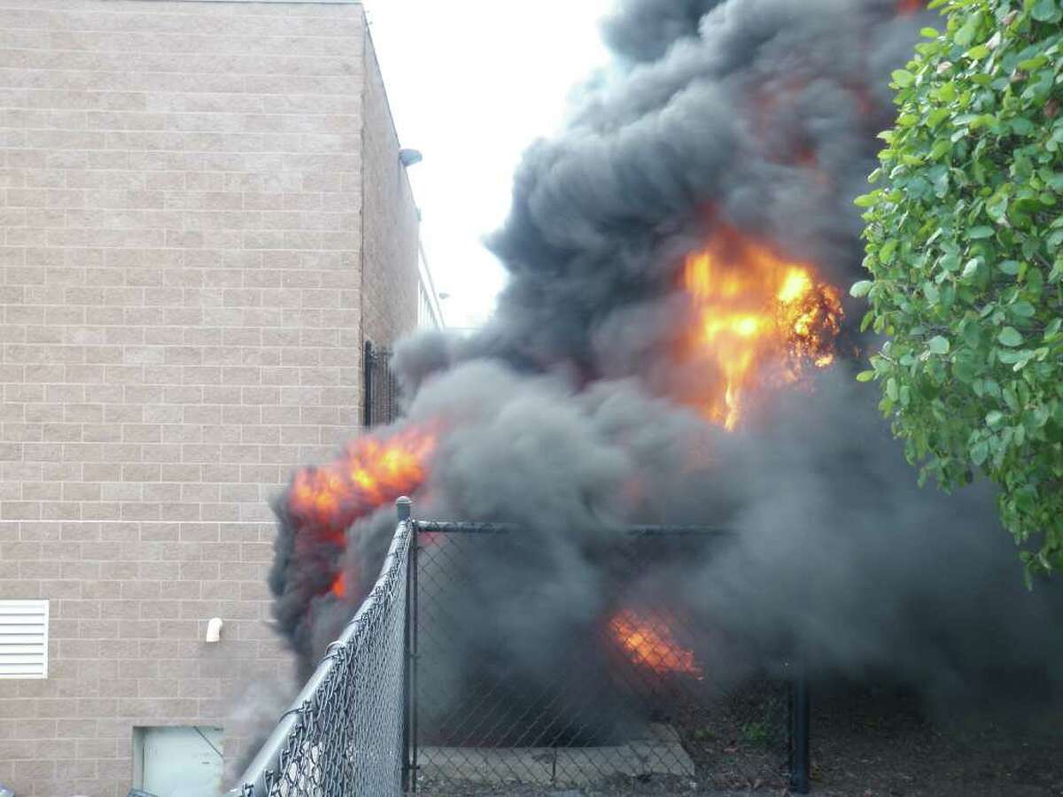 Flames erupted from old computers piled next Bedford Middle School's loading dock Tuesday afternoon, licking the side of the structure before firefighters extinguished the blaze.