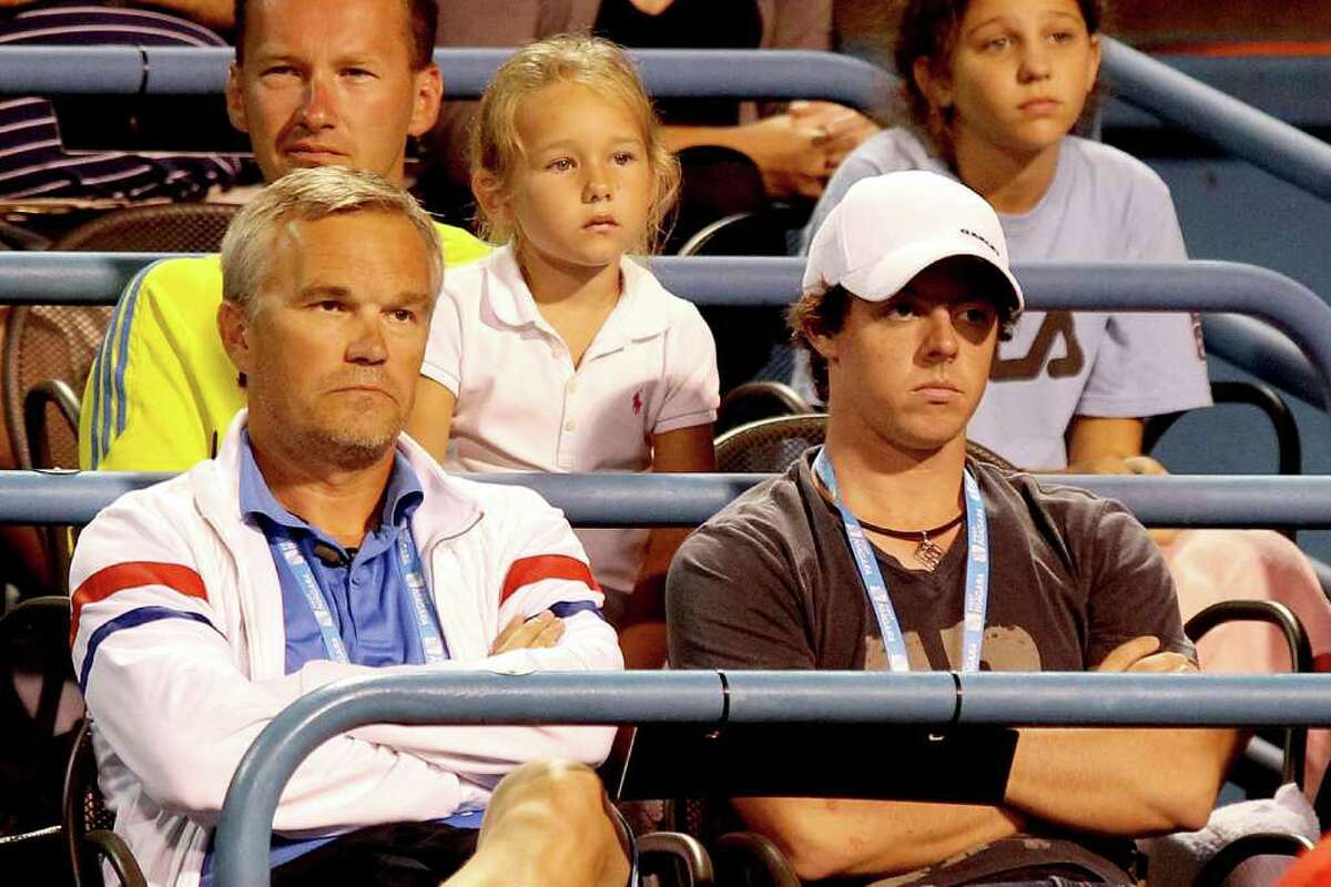 Piotr Wozniacki and professional golfer Rory McIlroy watch Caroline Wozniacki of Denmark play Christina McHale during the New Haven Open at Yale presented by First Niagara at the Connecticut Tennis Center on August 25, 2011 in New Haven, Connecticut.