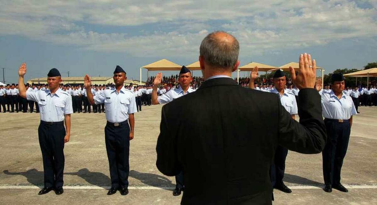 U.S. Citizenship and Immigration Services Associate Director Donald Monica (back to camera) administers the Oath of Allegiance to five Air Force trainees at Lackland AFB. The five became the first members of the Air Force to become U.S. citizens the day before they graduated from basic training. The trainees are Jared Garcia from the Philippines (from left), Ariful Haque from Bangladesh, Louise Quinsay from the Philippines, Kurt Danggoec from the Philippines and Daniela Negrete from Mexico.