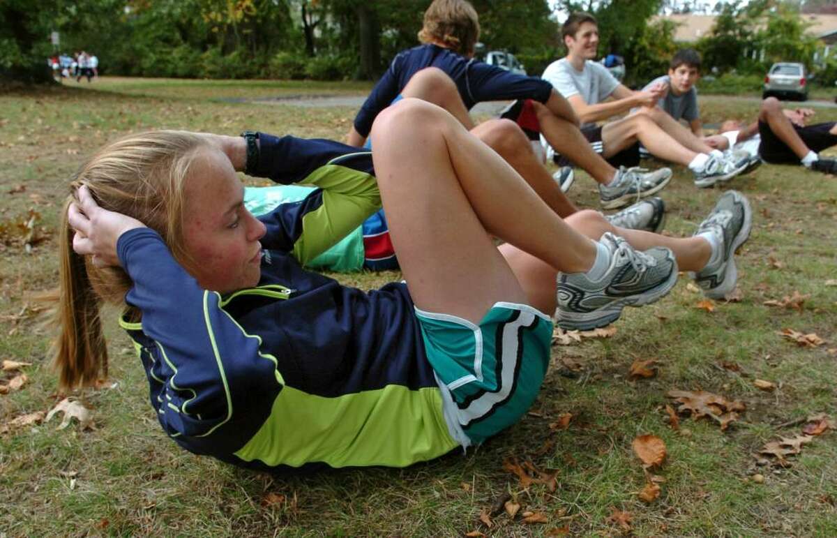 Bunnell High cross country runner Lauren Sara stretches before going on an eight mile run at the school in Stratford, Conn. on Wednesday Oct. 14, 2009.