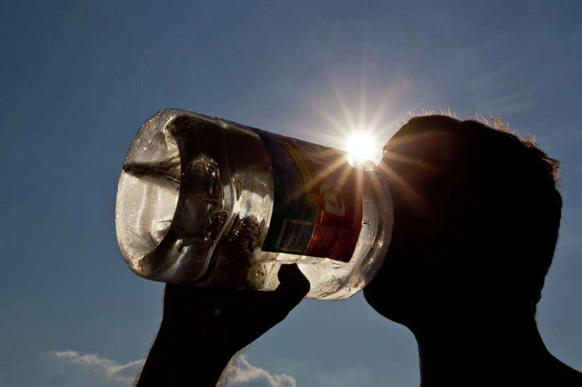 Chad Valentine tries to beat the heat with a drink of water at Alexander Deussen Park on Lake Houston on Saturday.