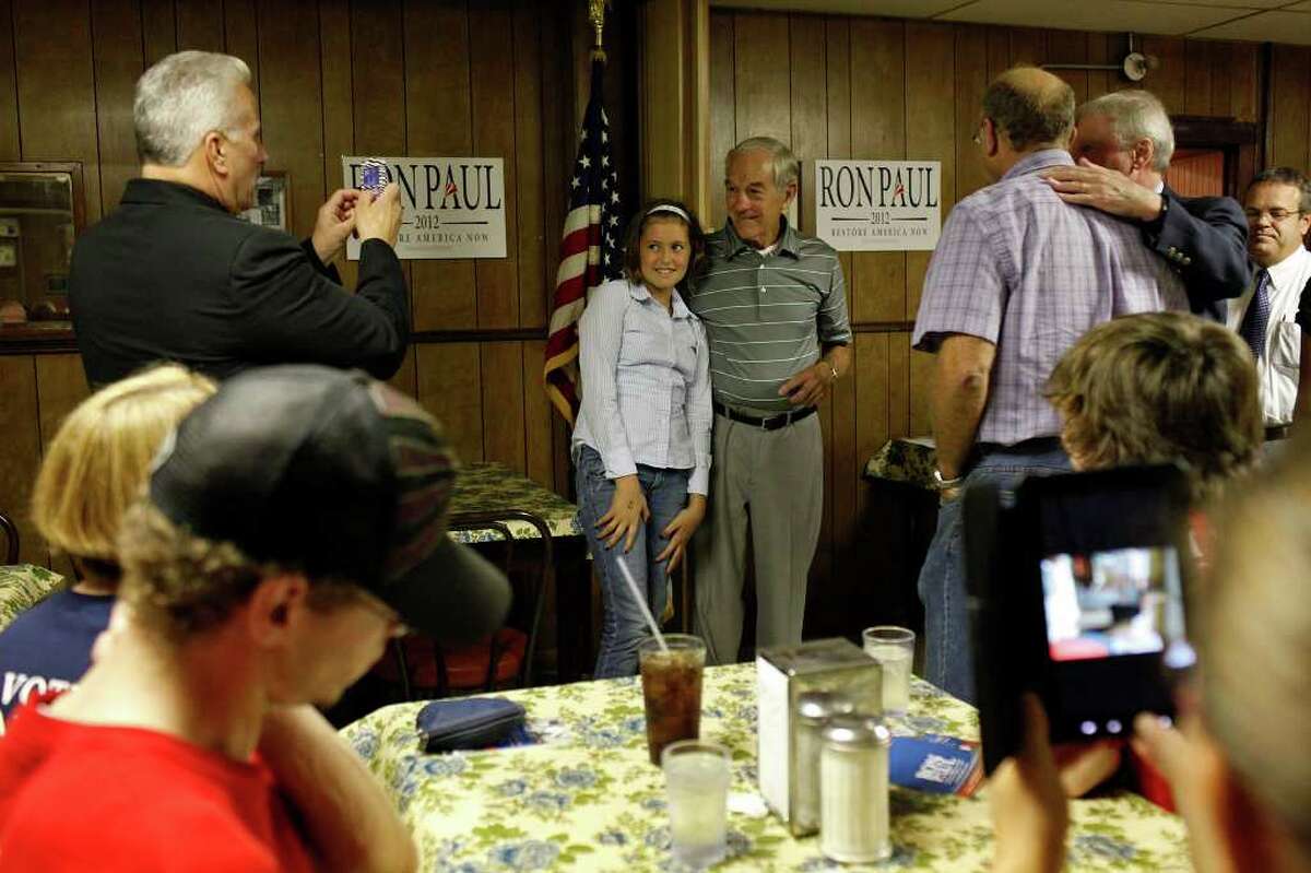 Congressman Ron Paul of Texas poses with Gabby Harvey, 12, as he campaigns at the Northside Cafe in Winterset, IA on Saturday, August 27, 2011.