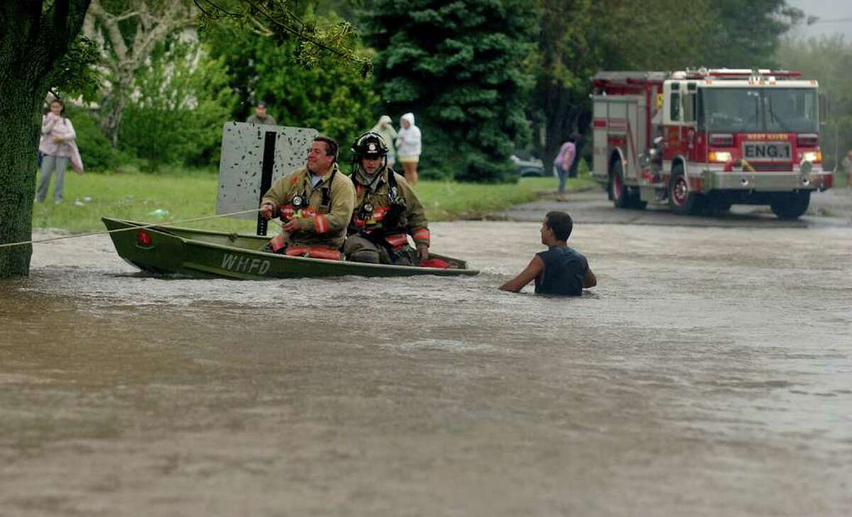 West Haven firefighters use a boat to go door to door looking for stranded residents along Morse Street in West Haven, Conn. on Sunday August 28, 2011.