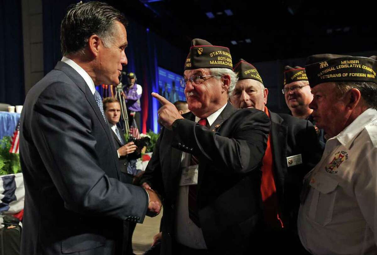Presidential candidate Mitt Romney, left, is greeted by Joseph N. Stavolta of Massachusetts, center, and other veterans after Romney addressed the veterans at the VFW National Convention at the Henry B. Gonzalez Convention Center, Tuesday, August 30, 2011.