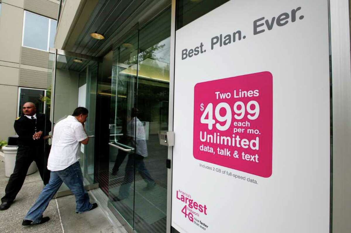 A door is held open for a man entering the T-Mobile corporate headquarters Wednesday, Aug. 31, 2011, in Bellevue, Wash. The Justice Department filed suit Wednesday to block AT&T's $39 billion deal to buy T-Mobile USA on grounds that it would raise prices for consumers. The government contends that the acquisition of the No. 4 wireless carrier in the country by No. 2 AT&T would reduce competition and that would lead to price increases. (AP Photo/Elaine Thompson)