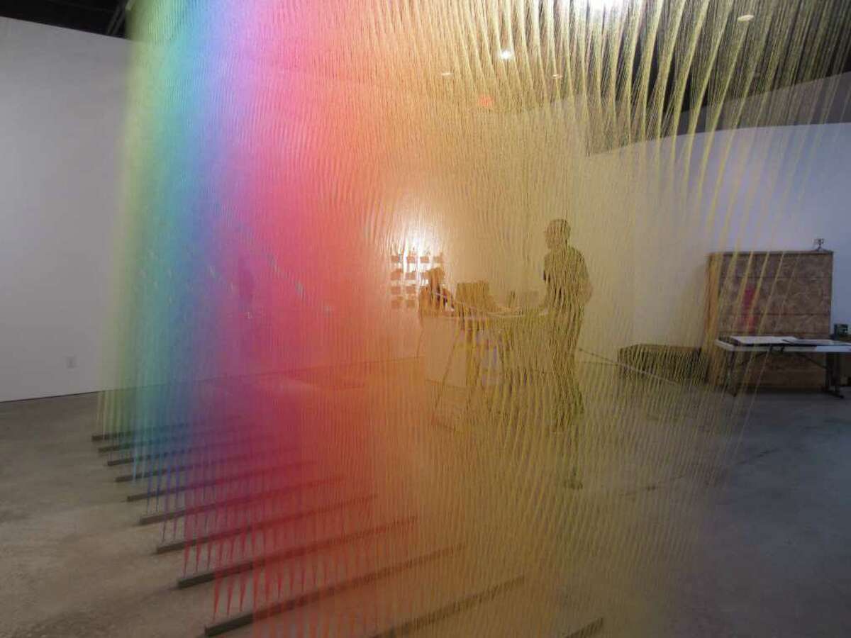 Gabriel Dawe works on installing a sculpture consisting of thousands of yards of thread at Peel Gallery.