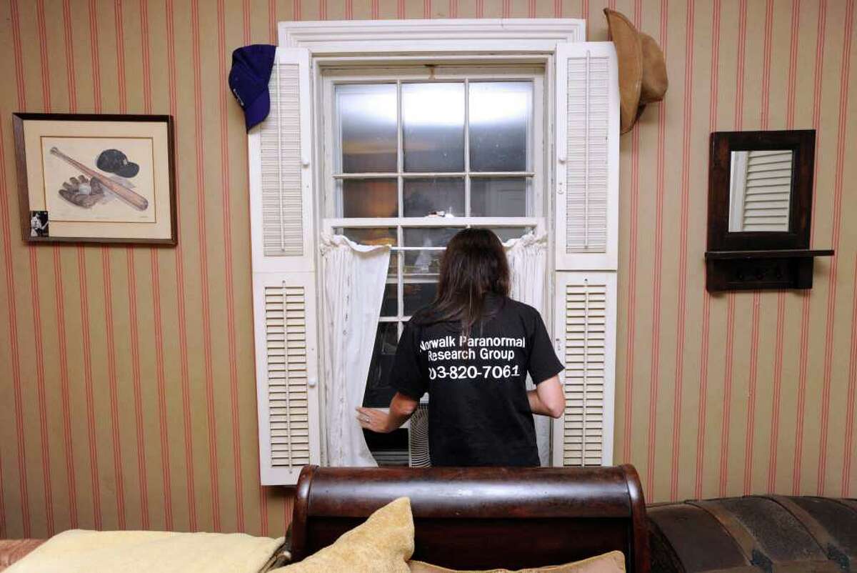 Lisa Harrington of the Norwalk Paranormal Research Group looks out a bedroom window while searching for spirit that Melissa Leigh says haunts her backcountry Stamford home, Friday night, Sept. 2, 2011. The house was owned at one time by Vivian Vance who was best known for her role as Ethel Mertz on the television sitcom "I Love Lucy."