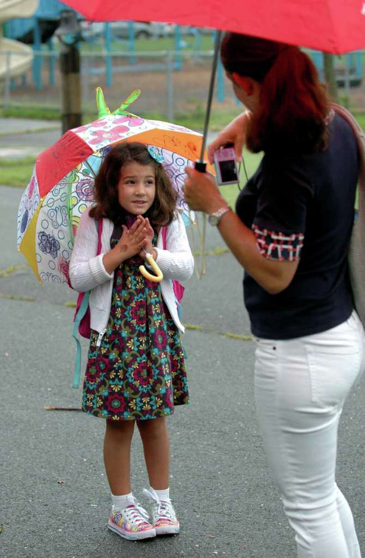 Keri O'Neill takes a photo of her daughter, Grace O'Neill outside Roger Sherman School on the first day of classes in Fairfield, Conn. on Tuesday Sept. 6, 2011.