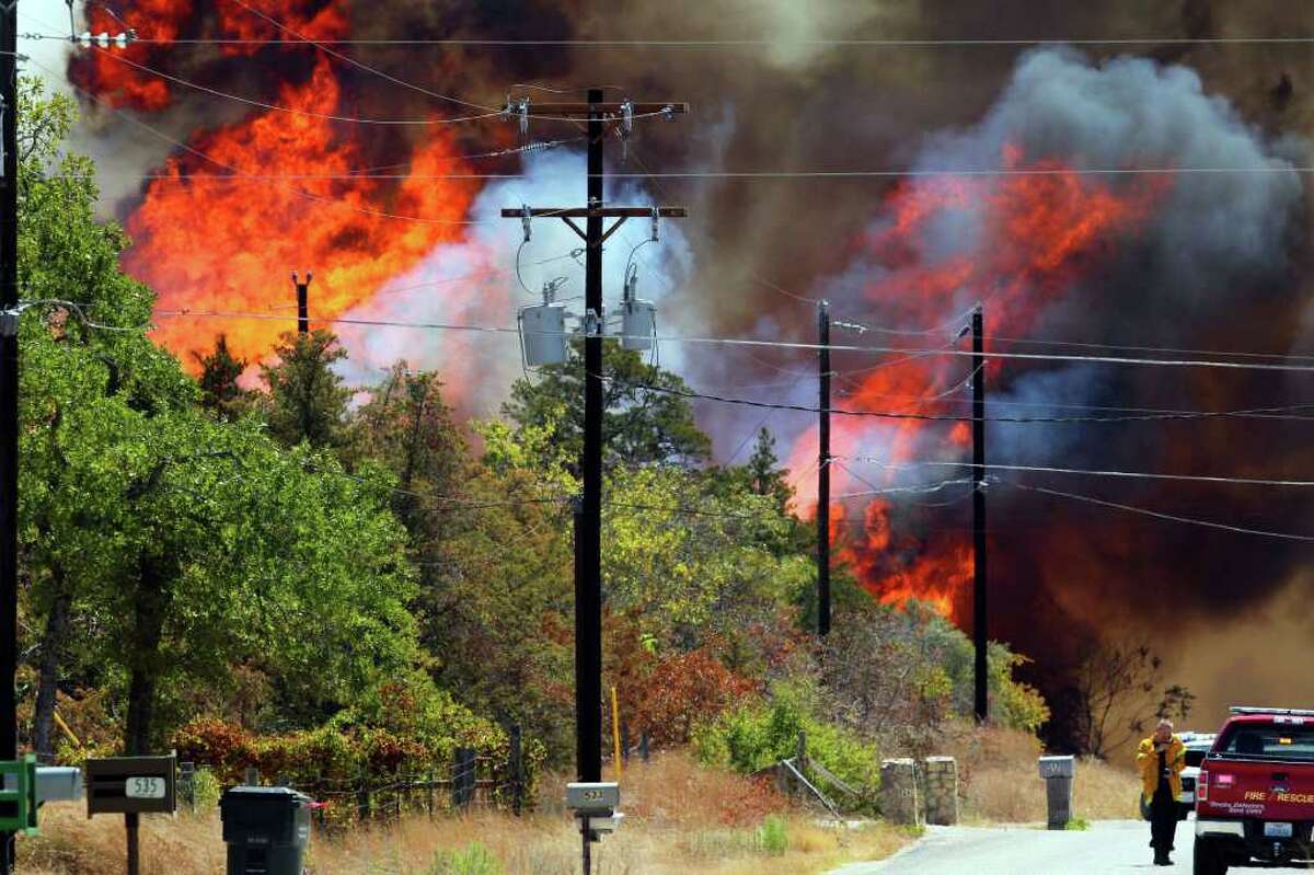 Fire rages on Leisure Lane in a neighborhood near the west end of Bastrop, Texas off Highway 71 Monday September 5, 2011. Fires have been burning through many areas in central Texas as authorities try to gain control of the blazes.
