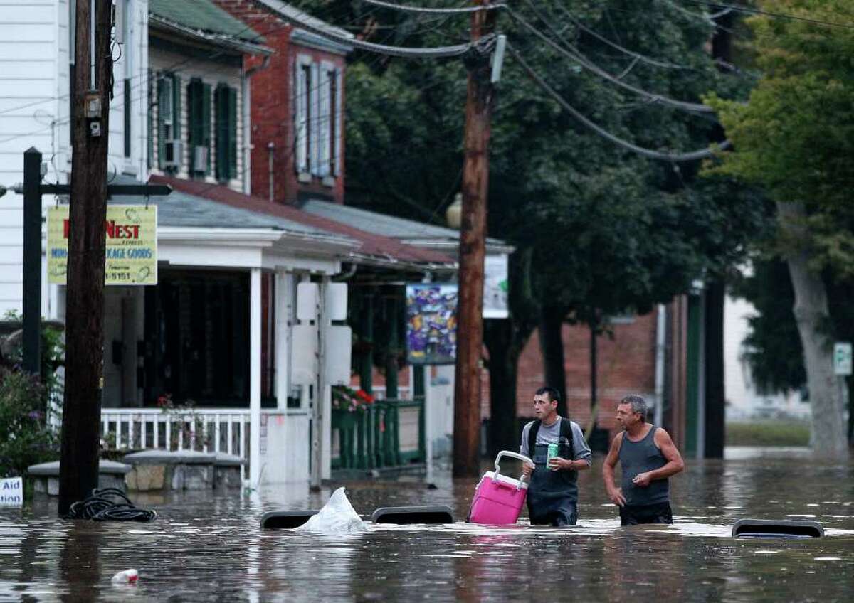 Johnny Bowman, Jr., left, and his father Johnny, Sr., walk down a flooded street in Port Deposit, Md., Thursday, Sept. 8, 2011, as the Susquehanna River, which is swollen with rain from the remnants of Tropical Storm Lee, continues to rise. Johnny, Sr., was helping his son move belongings to an upper floor in his home before evacuating.