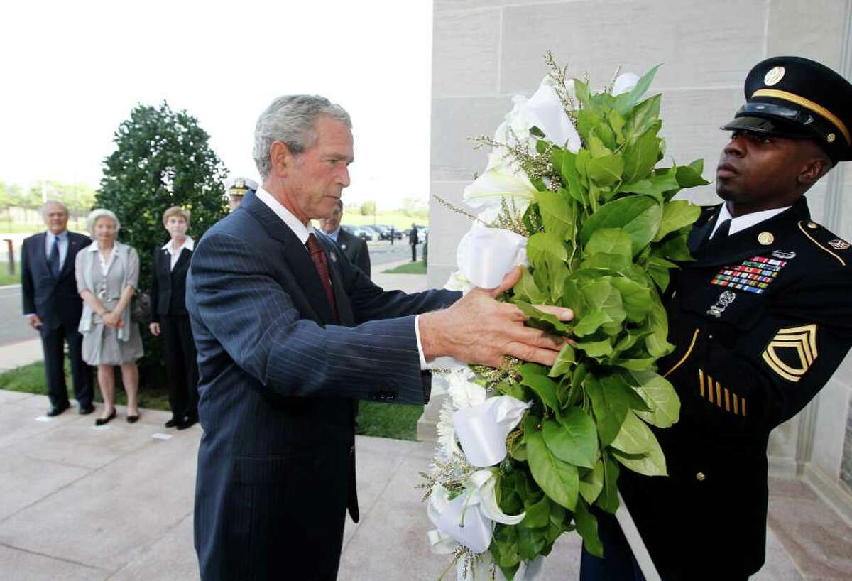 Former President George W. Bush lays a wreath at the Pentagon in Washington in commemoration of the 10th anniversary of the Sept. 11 attacks, Saturday, Sept. 10, 2011. Pictured at rear, left to right: former Defense Secretary Donald Rumsfeld, his wife Joyce Rumsfeld, Deborah Mullen, Chairman of the Joint Chiefs of Staff Adm. Mike Mullen, and Defense Secretary Leon Panetta. (AP Photo/Charles Dharapak)