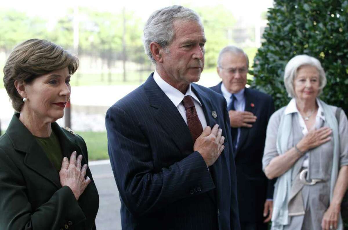 Former President George W. Bush and former first lady Laura Bush, along with former Defense Secretary Donald Rumsfeld and his wife Joyce Rumsfeld, pause for a moment of silence after laying a wreath at the Pentagon in Washington in commemoration of the 10th anniversary of the Sept. 11 attacks, Saturday, Sept. 10, 2011. (AP Photo/Charles Dharapak)