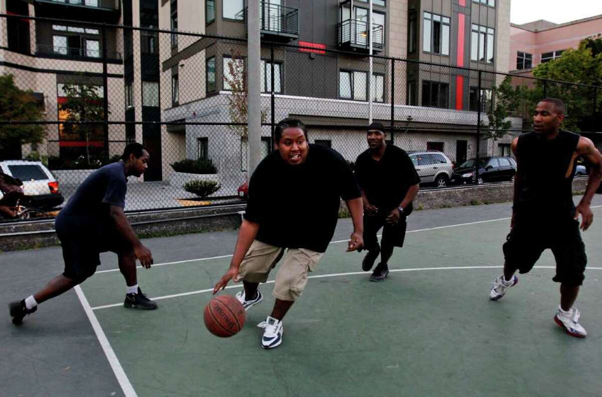 Left to right; Horace, Charles Hunter, Condel Walker, and Tony play basketball at Cal Anderson Park.