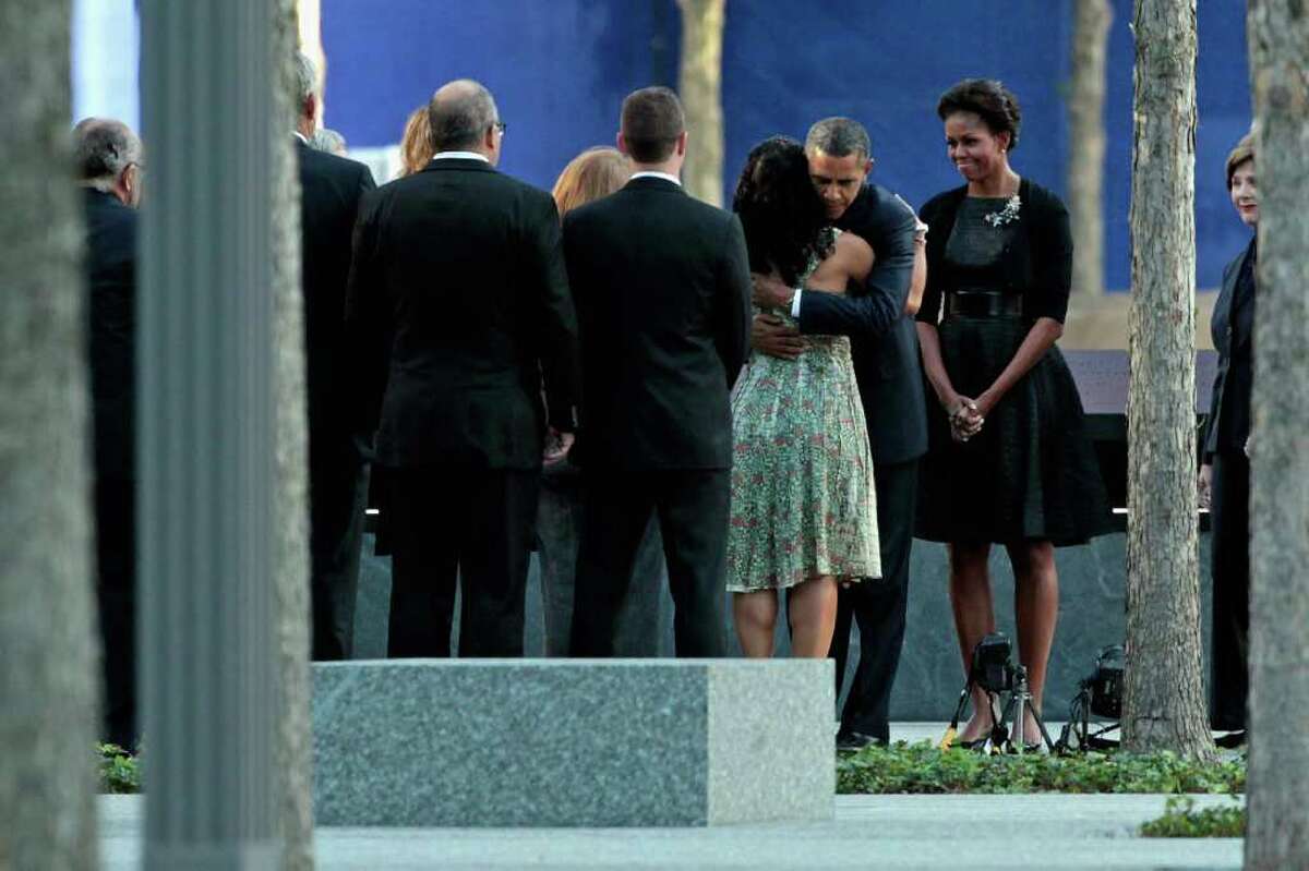 NEW YORK, NY - SEPTEMBER 11: U.S. President Barack Obama (2nd R) embraces victims' family members as first lady Michelle Obama (R) stands by at the 9/11 Memorial during the tenth anniversary ceremonies of the September 11, 2001 terrorist attacks at the World Trade Center site, September 11, 2011 in New York City. New York City and the nation are commemorating the tenth anniversary of the terrorist attacks on lower Manhattan which resulted in the deaths of 2,753 people after two hijacked planes crashed into the World Trade Center. (Photo by Chip Somodevilla/Getty Images)