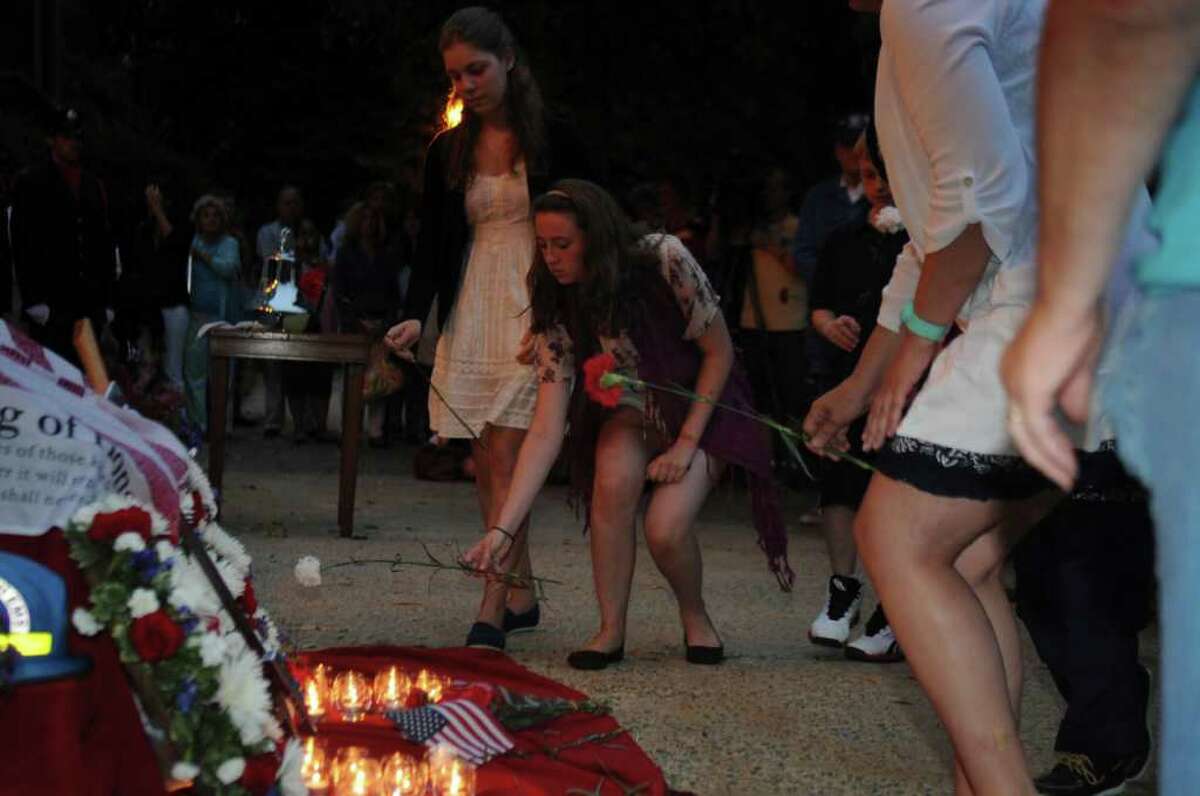 People put flowers at the 23 candles during Greenwich's September 11th to honor the memory of those lost on 9/11, especially the 23 residents who died, in a ceremony in front of the Greenwich Town Hall on Sept. 11, 2011.