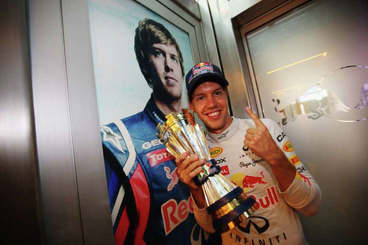 MONZA, ITALY - SEPTEMBER 11: Sebastian Vettel of Germany and Red Bull Racing celebrates with the winning drivers trophy following the Italian Formula One Grand Prix at the Autodromo Nazionale di Monza on September 11, 2011 in Monza, Italy. (Photo by Mark Thompson/Getty Images)