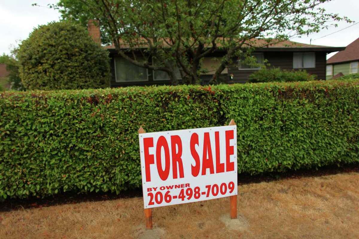 A homeowner erected a large "for sale" sign in front of a home on Sand Point Way Northeast in this September 2011 file photo.