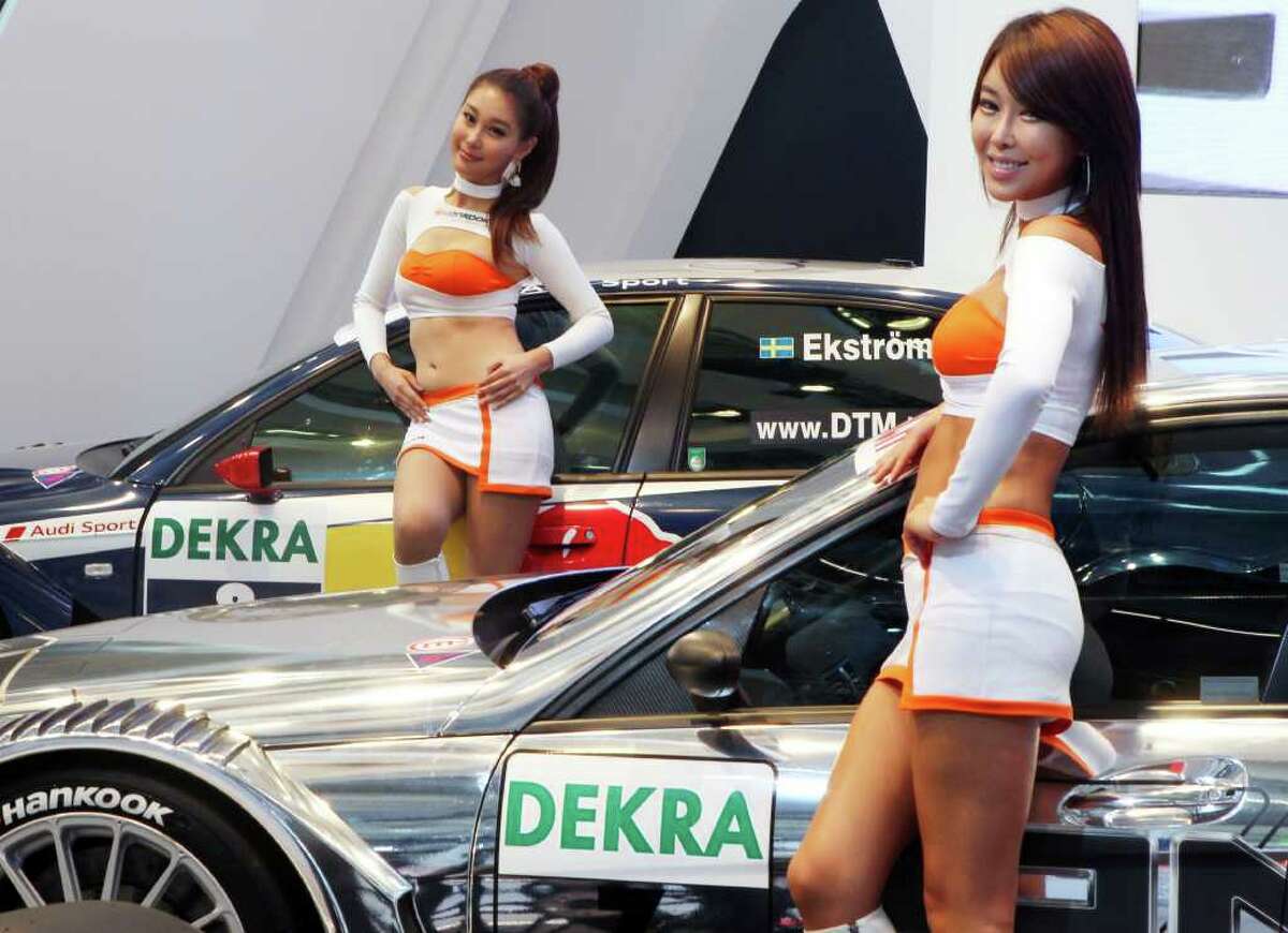 Models pose next to DTM race cars at the 64th Frankfurt Auto Show in Frankf...