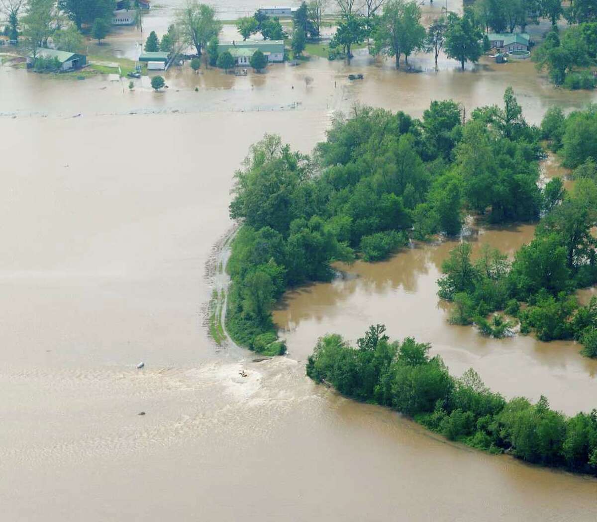 ASSOCIATED PRESS FILE MUCH WATER, BIG BILL: Water from the Black River flows through a breach in a levee near Poplar Bluff, Mo. Repairs to the levees may cost billions, federal officials say.