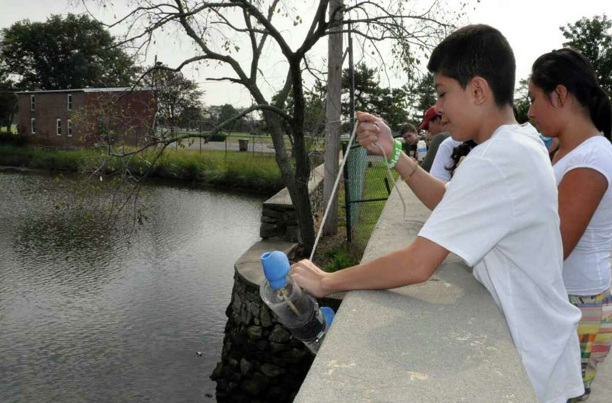 Jorge Palentia, an eighth grader at Scofield Magnet Middle School, collects a water sample from Holly Pond while on a field trip to the SoundWaters Coastal Center in Stamford on Thursday, Sept. 15, 2011.