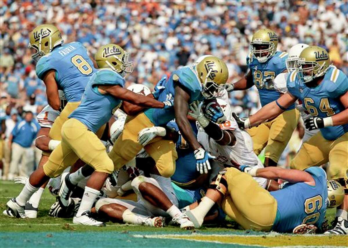 UCLA running back Derrick Coleman, middle, dives into the end zone for at touchdown during the second half of an NCAA college football game against Texas, Saturday, Sept. 17, 2011, at the Rose Bowl in Pasadena, Calif. Texas won 49-20. (AP Photo/Bret Hartman)