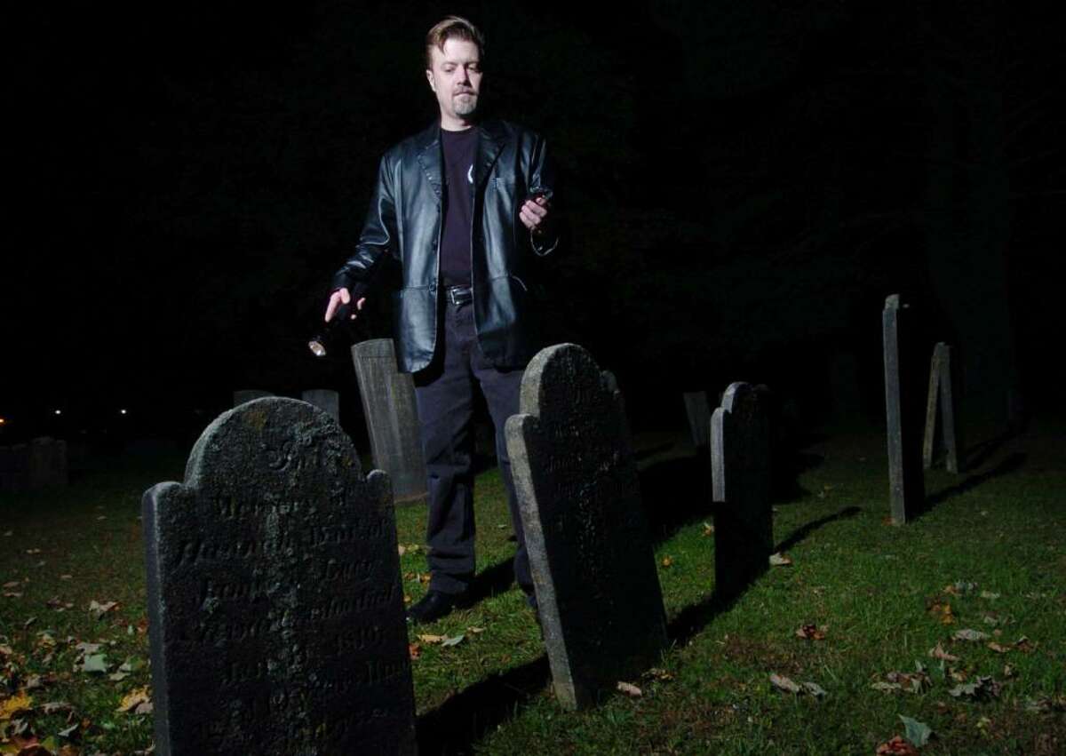 Nathan Schoonover, from Danbury, demonstraits how he investigates for ghosts at a grave yard in Danbury, Thursday, Oct. 8, 2009.