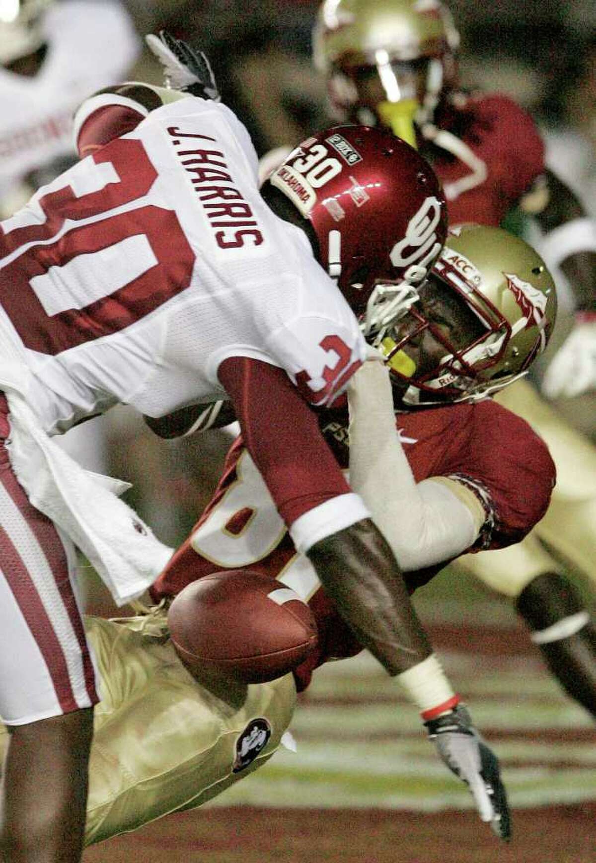 STEVE CANNON: ASSOCIATED PRESS VICIOUS: Florida State receiver Kenny Shaw loses the ball as he gets hit by a pair of Oklahoma players, including Javon Harris (30), during the second quarter Saturday. Shaw was taken to a hospital by ambulance but was able to give the crowd a thumbs-up with his left hand before departing.