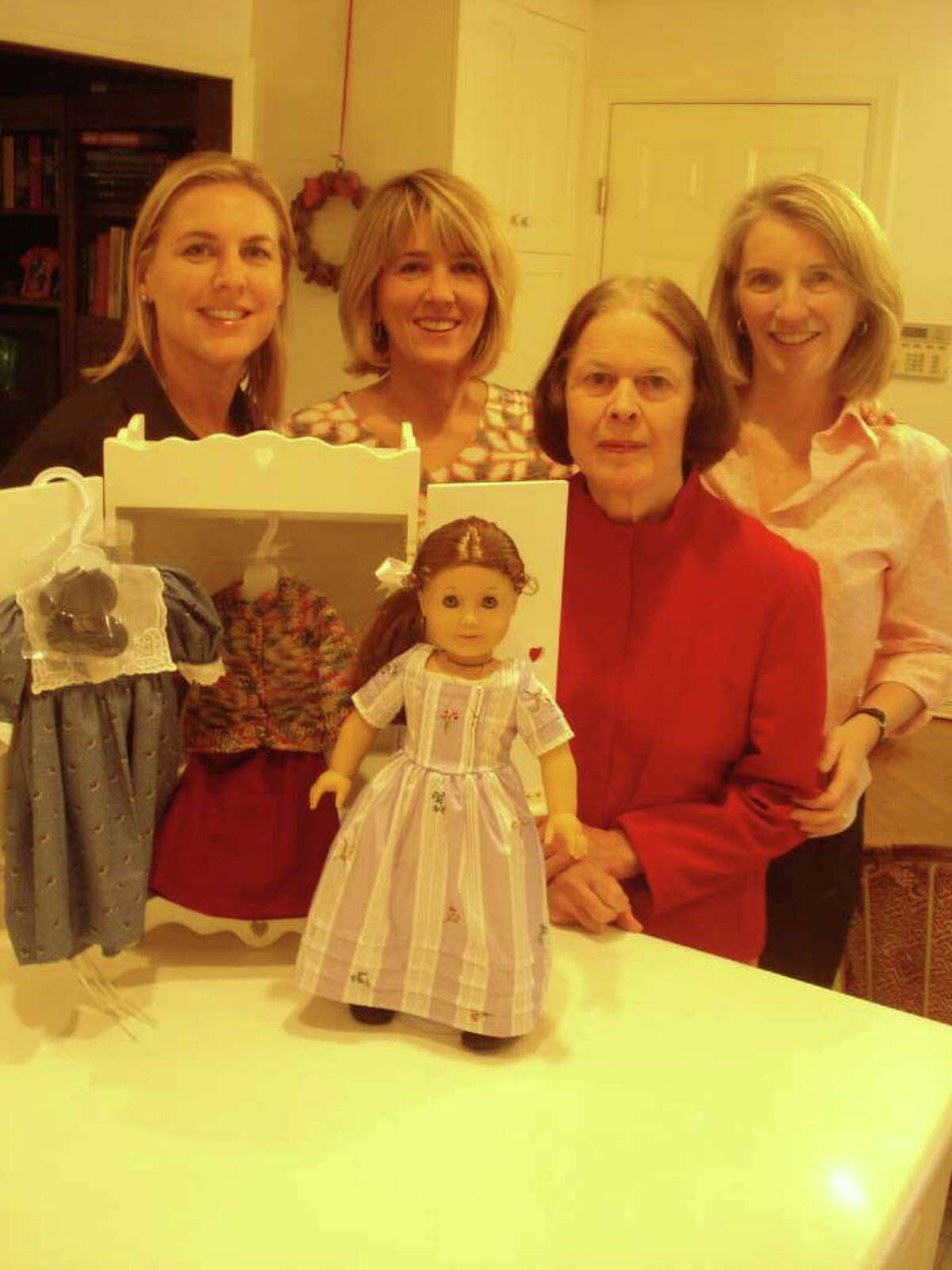 Getabout Fall Fundraiser Committee members back row, from left, Katherine Ong, Rene Kemp and Robin Busch admire the American Girl hand-sewn doll package auction item, contributed by fellow committee member Ruth Witt (front). Getabout's annual fundraiser and silent auction is scheduled for Sunday, Oct. 16 at New Canaan Country Club.