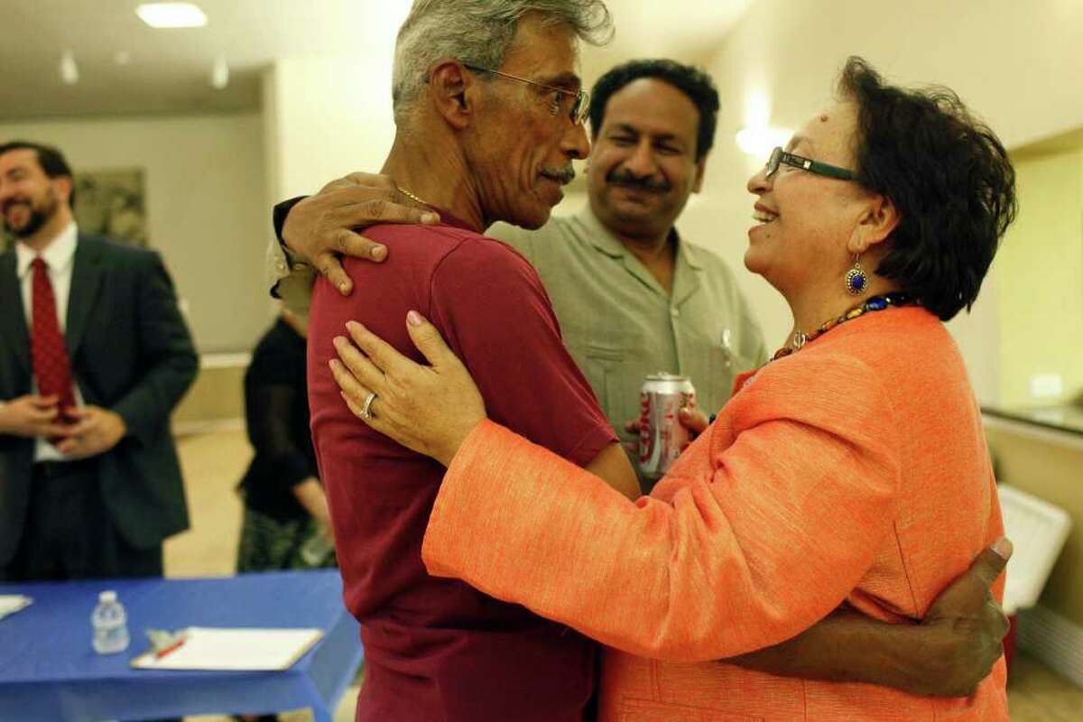 Bexar County Democratic Party Chairwoman Choco Meza (right) embraces James Lucas (left) and Ali Masarrat during the party's candidate petition signing party at Firefighters Hall on Tuesday, Sept. 20, 2011. Meza said she has enough pledges to pay off the organization’s debt and plans to collect them at an Oct. 14 fundraiser.