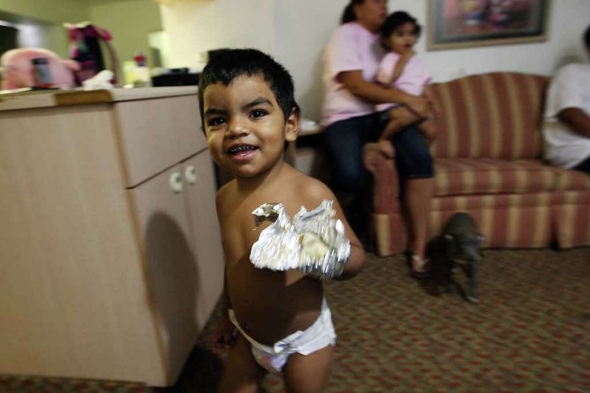 Alex Serrano Jr., 1, walks around the motel room where his family is staying until their apartment at the Alazan-Apache Courts is treated for roaches and mice. Pests have been found in several units at the complex.