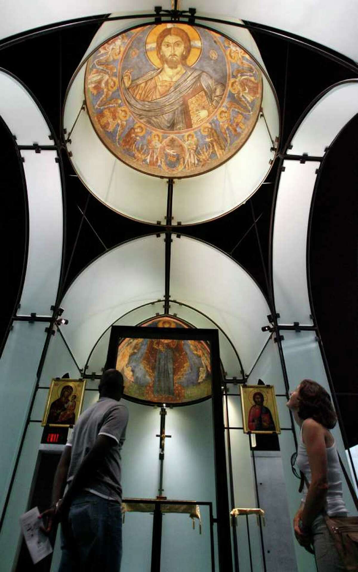 Visitors Mohamed Ndao, (cq) left, and Victoria Gardener,(cq) right, look at the multi-colored frescos on the dome and sides of the glass walls of the Byzantine Chapel, Thursday, Sept. 27, 2007. The Chapel is the only repository in the United States with intact Byzantine frescoes in the entire western hemisphere. These masterworks from the 13th century -- a dome and an apse -- were ripped and stolen out of a chapel near Lysi in Cyprus in the 1980's, cut into pieces, and smuggled off the island by thieves prepared to sell them piece by piece. The fresco fragments were rescued from the thieves by The Menil Foundation with the knowledge and approval of the Church of Cyprus, the rightful owner of the frescoes. ( Karen Warren / Chronicle)