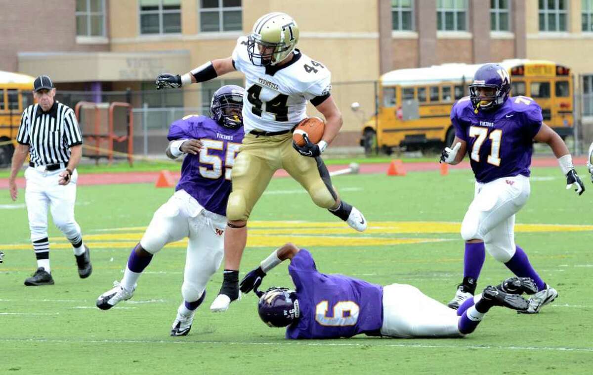 Trumbull's Don Cherry (44) carries the ball for yardage leaping over Westhill's Ryan Burke (6) during the football game at Westhill High School in Stamford on Saturday, Sept. 24, 2011.
