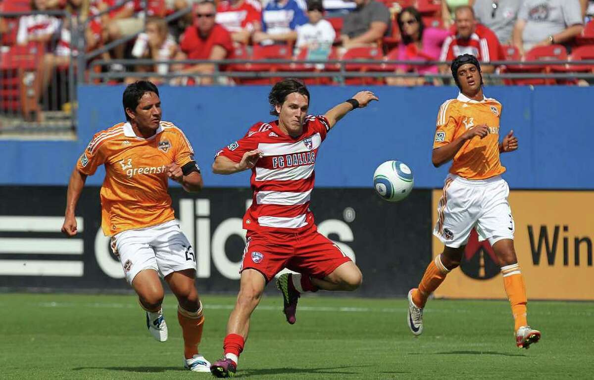 FRISCO, TX - SEPTEMBER 24: Eric Avila #12 of FC Dallas dribbles the ball against Brian Ching #25 of the Houston Dynamo at Pizza Hut Park on September 24, 2011 in Frisco, Texas.