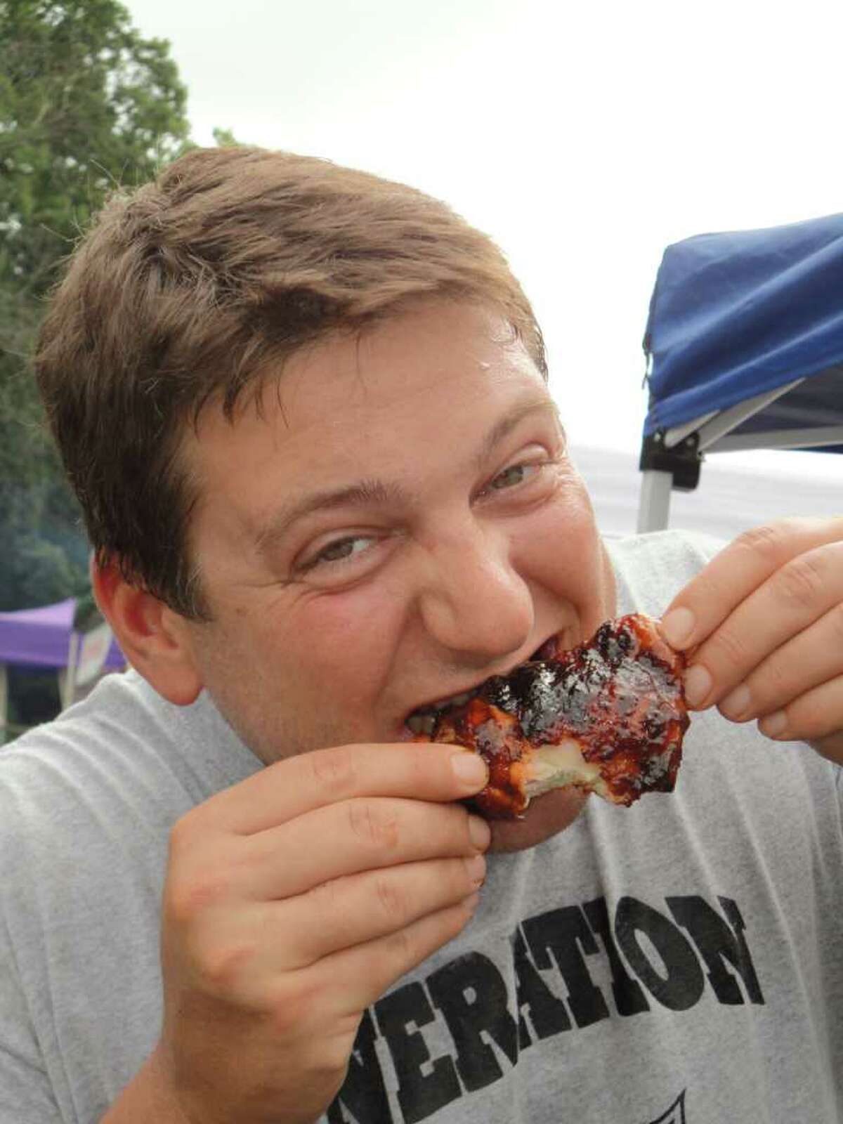 Scott Braun, a member of the team Generation Swine, tastes a barbecued chicken thigh on a break from working on his teamís entry in the 4th annual Blues, Views & BBQ Festival. Generation Swineís chicken took first place in the Backyard Chef portion of the competition last year and second place overall.