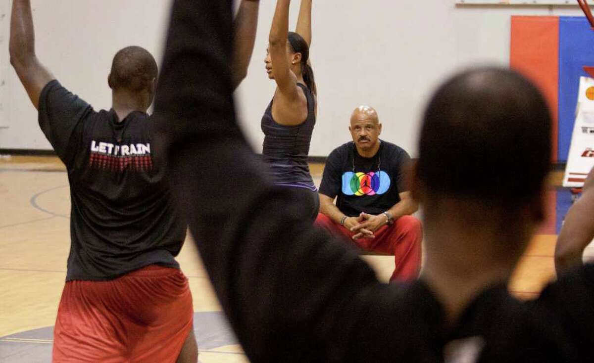 John Lucas, center, watches as Monique Dotson conducts yoga exercises twice a week as part of Lucas' multifaceted basketball training program at Lutheran North High School.