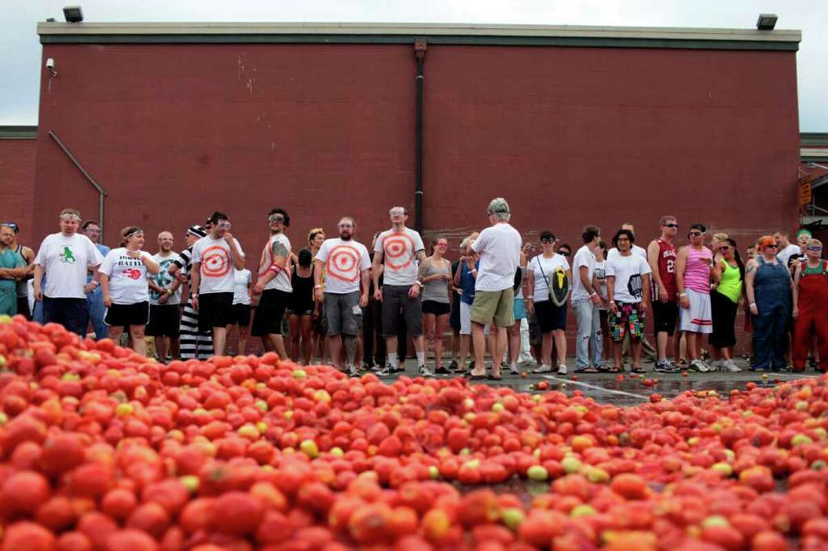 Hundreds of attendees wait before 300,000 pounds of overripe tomatoes.