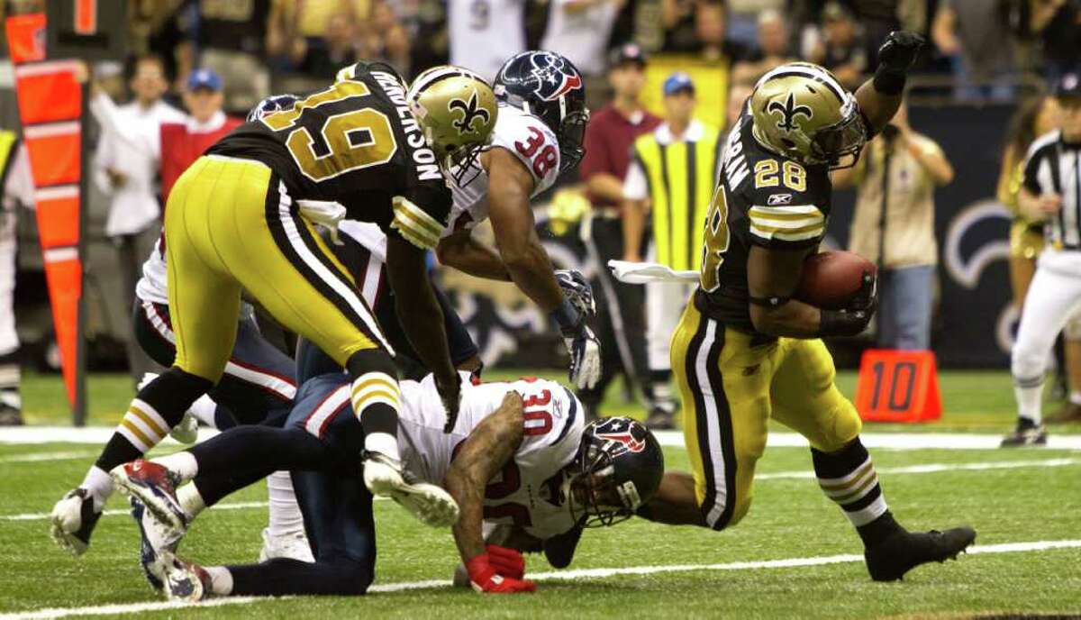 New Orleans Saints running back Mark Ingram (28) runs past Houston Texans cornerback Jason Allen (30) and Houston Texans free safety Danieal Manning (38) for a 13-yard touchdown run during the fourth quarter of an NFL football game at the Louisiana Superdome Sunday, Sept. 25, 2011, New Orleans. The Saints beat the Texans 40-33.