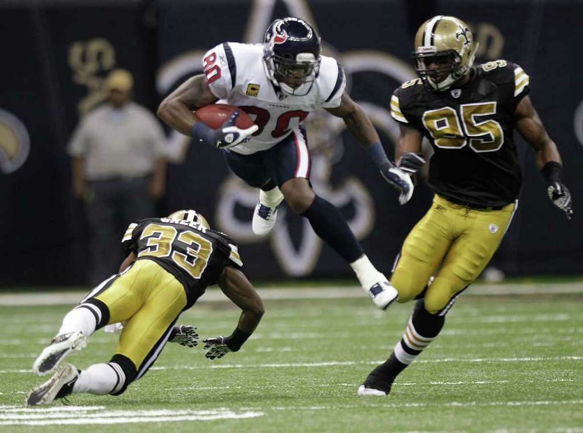 Houston Texans wide receiver Andre Johnson (80) leaps over New Orleans Saints cornerback Jabari Greer (33) during the first quarter of an NFL football game at the Louisiana Superdome Sunday, Sept. 25, 2011, New Orleans. The Saints beat the Texans 40-33.