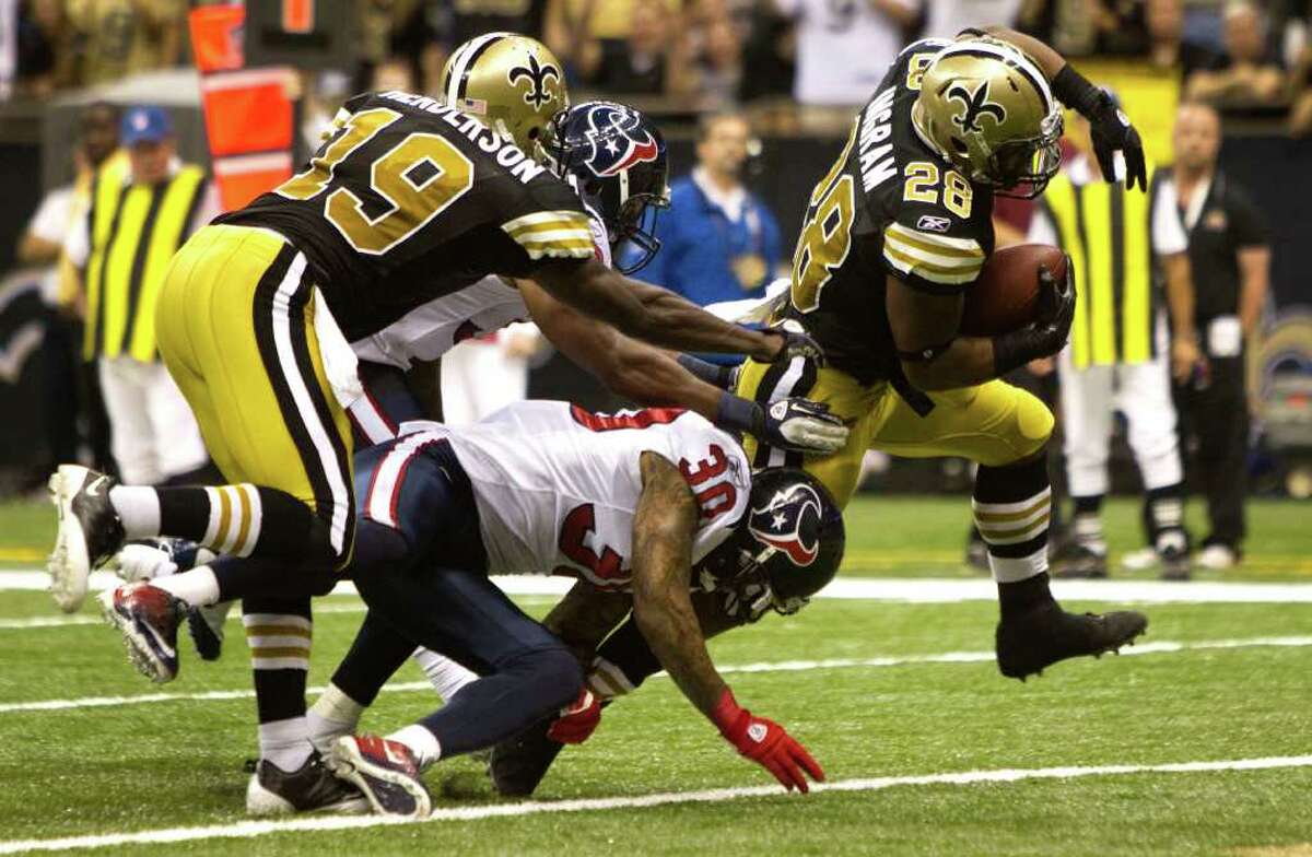 New Orleans Saints running back Mark Ingram (28) runs past Houston Texans cornerback Jason Allen (30) and Houston Texans free safety Danieal Manning (38) for a 13-yard touchdown run during the fourth quarter of an NFL football game at the Louisiana Superdome Sunday, Sept. 25, 2011, New Orleans. The Saints beat the Texans 40-33.