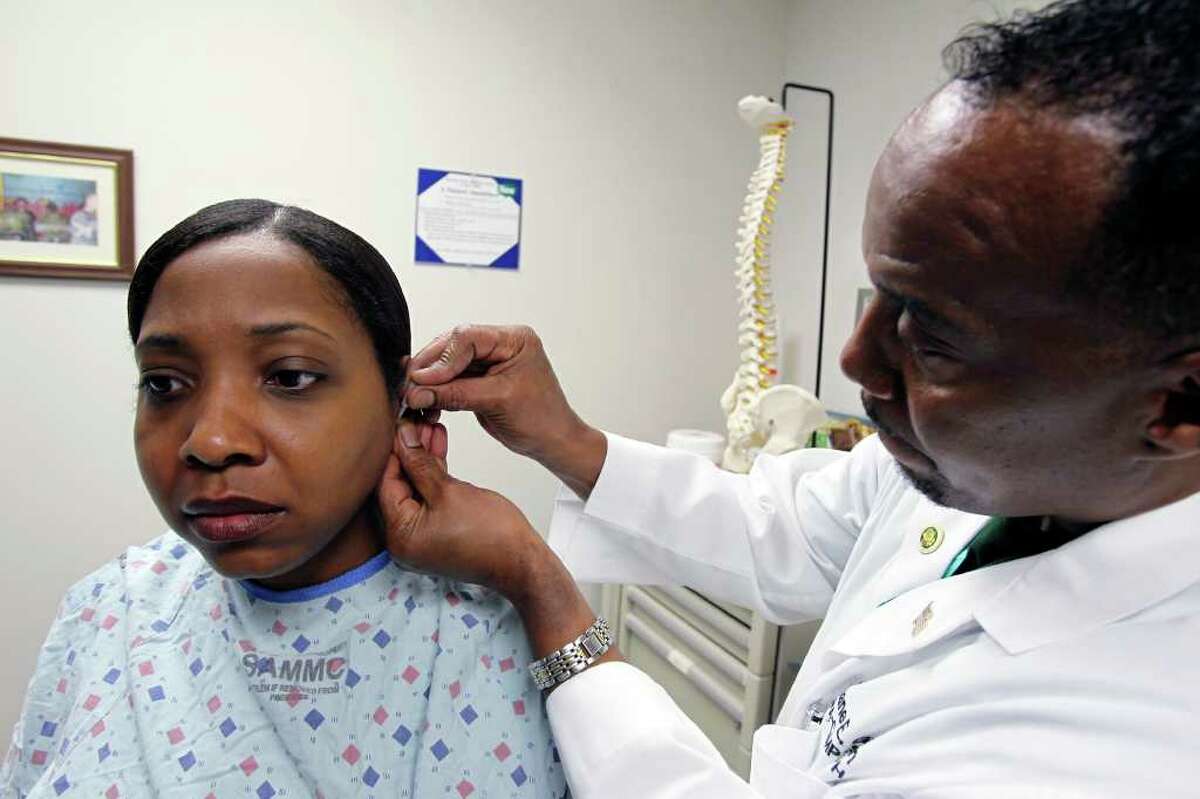 TOM REEL : SAN ANTONIO EXPRESS-NEWS A LITTLE STICK: Physician's assistant Duane Griffin administers acupuncture treatment to Capt. Natacha Johnson-Glover at Brooke Army Medical Center in San Antonio.