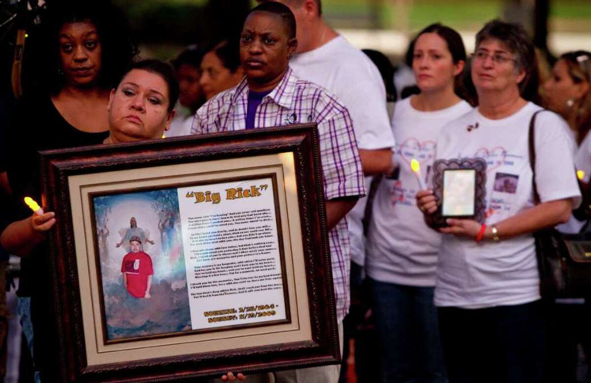 Maria Velasquez holds a picture of her son, Enrique Rick Velasquez, who was murdered in 2009, during the National Day of Remembrance for Murder Victims on Sunday outside Houston City Hall