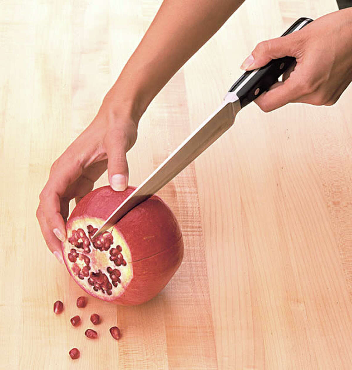 How to extract pomegranate seeds: Step 1: Cut off the crown; cut the pomegranate into sections. (Photo courtesy of the Pomegranate Council.)