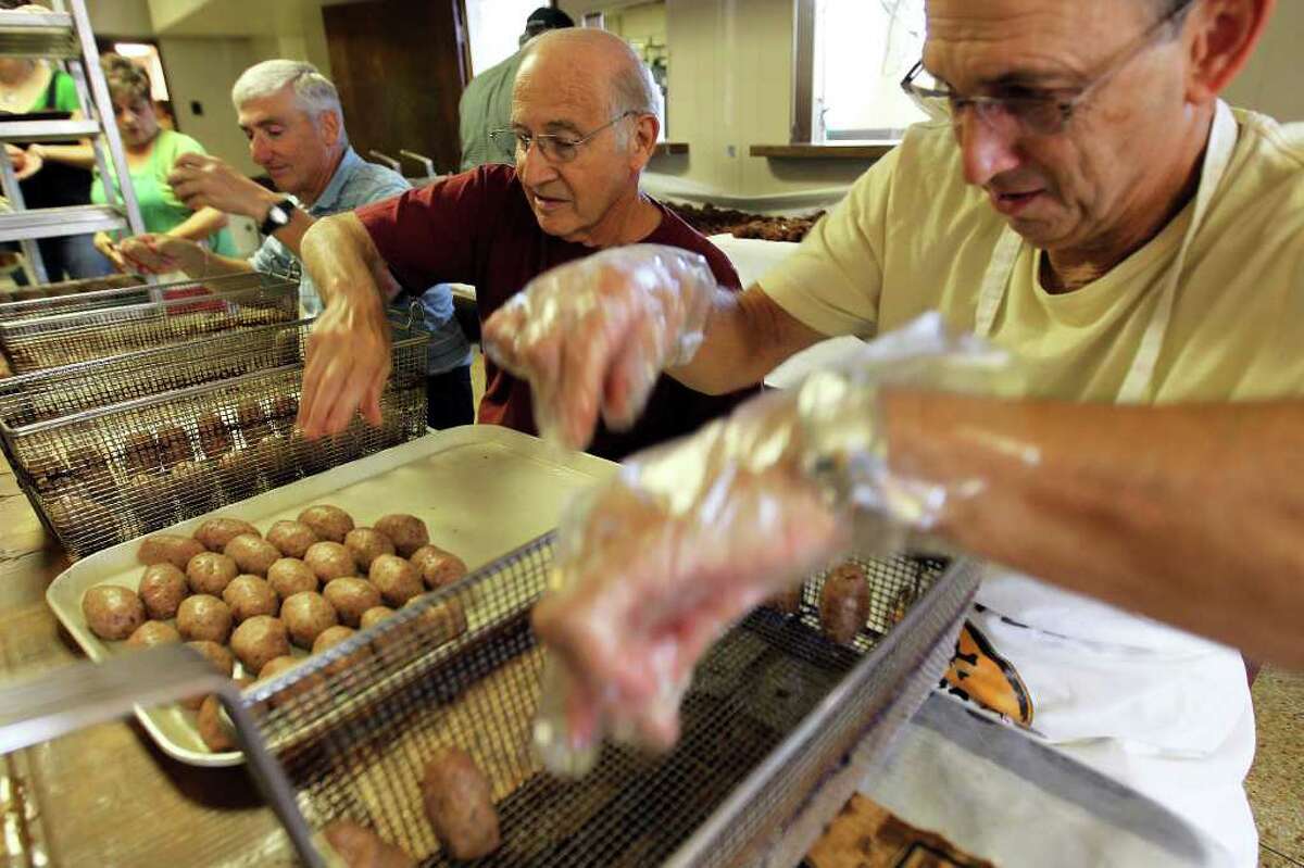 Christopher Columbus Society volunteers, from left, Ralph Paglia, Jim Mezzetti, and Richard Bertani, organize the meatballs into fryer baskets before they are cooked during preparations for the spaghetti dinner at Christopher Columbus Hall, Saturday, September 10, 2011. (Jennifer Whitney/ Special to the San Antonio Express-News)