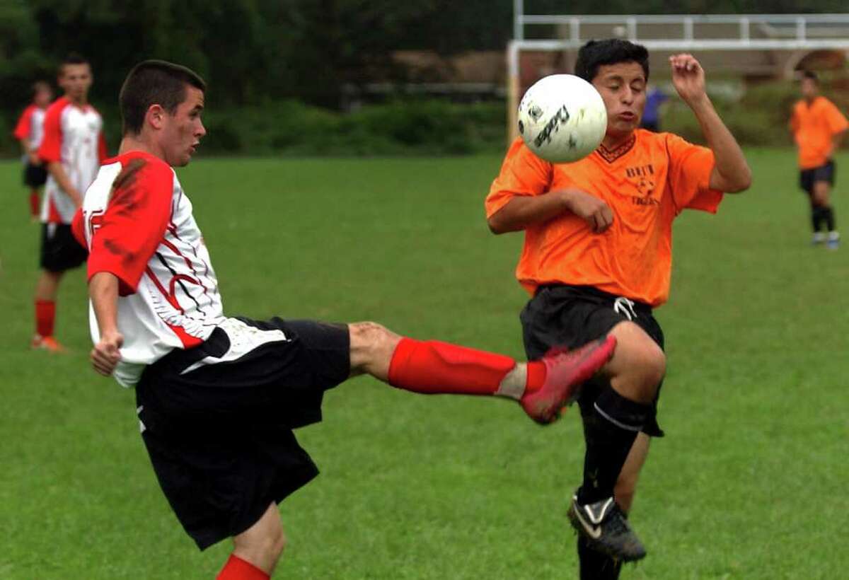 Platt Tech's #16 Aidan Lynch, left, kicks the ball as Bullard Havens' #13 Kendrick Galarza attempts to block, during boys soccer action in Milford, Conn. on Wednesday September 28, 2011.
