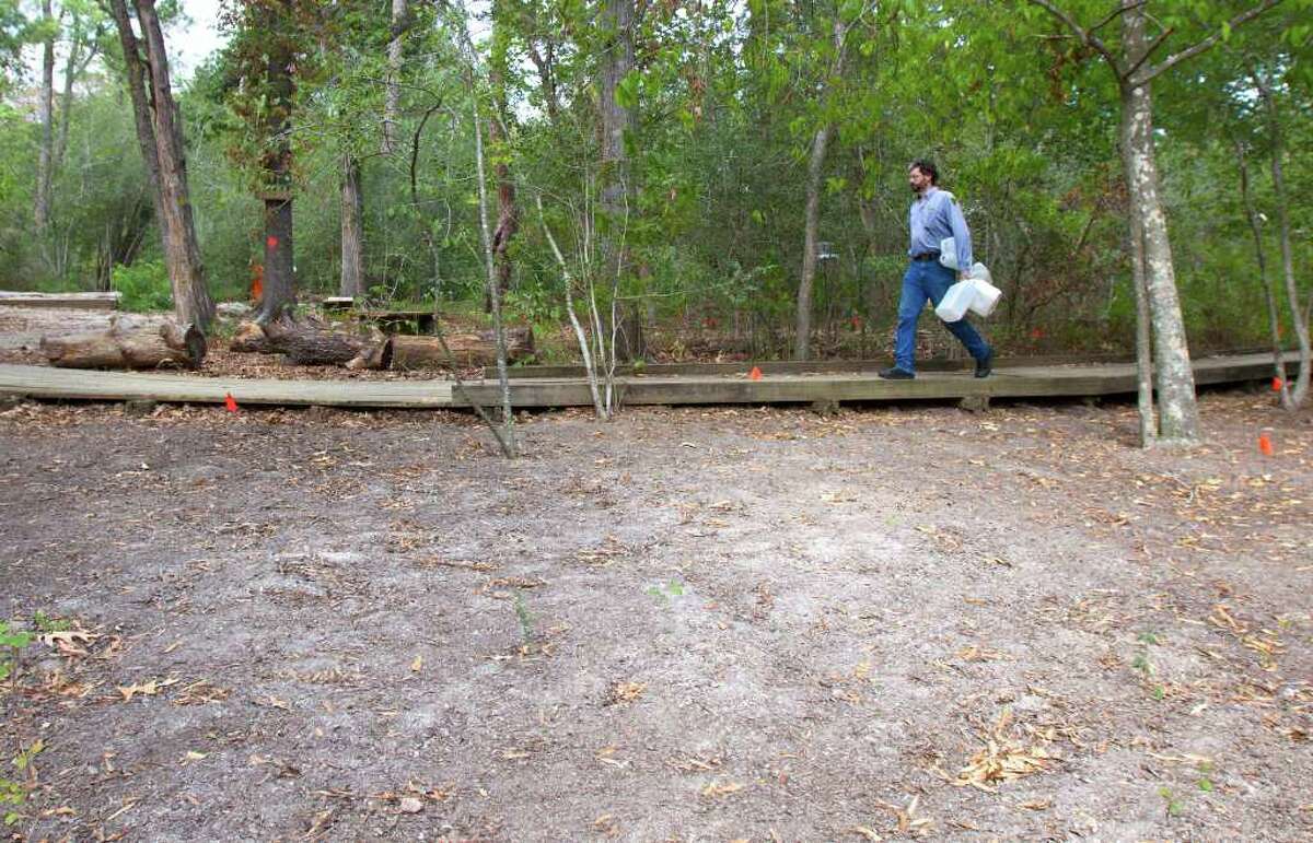Blanton carries water jugs for a trail improvement project Thursday at the Houston Arboretum & Nature Center. Volunteers are clearing areas within 100 feet of walkways and buildings at the arboretum due to fire concerns.